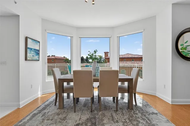 a dining room with furniture potted plants and wooden floor