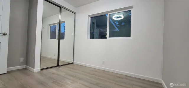 an empty room with wooden floor and mirror