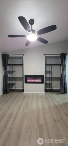 a view of an empty room with closet and a ceiling fan