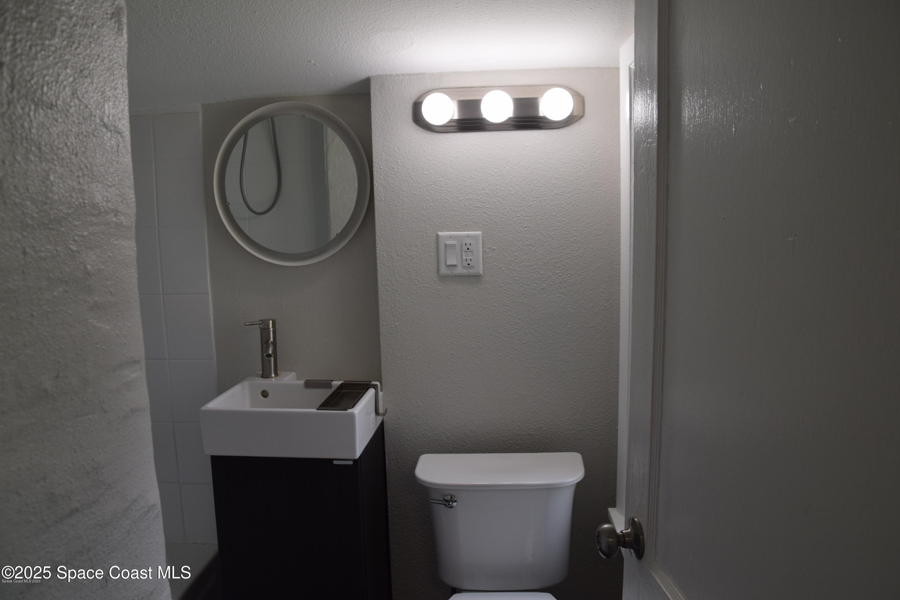 2100 Franklin Street, Unit 3 Melbourne, FL 32901 - Photo 16 of 22 a bathroom with a toilet a sink and mirror