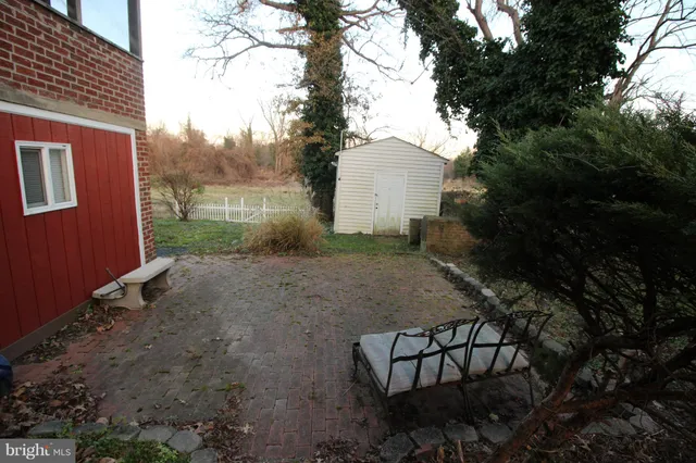 a view of a backyard with plants and bench