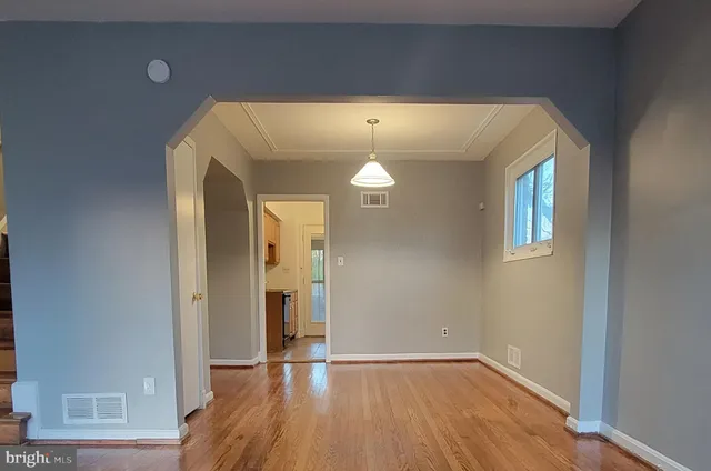 a view of empty room with wooden floor
