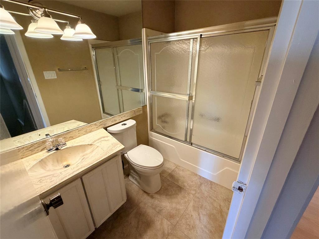 2051 Embassy Way Carrollton, TX 75006 - Photo 19 of 20 Bathroom featuring vanity, shower / bath combination with glass door, and tile patterned flooring