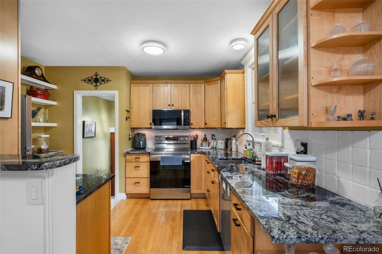 1136 Cook Street Denver, CO 80206 - Photo 13 of 42 a kitchen with stainless steel appliances granite countertop a stove top oven a sink dishwasher a refrigerator and cabinets with wooden floor