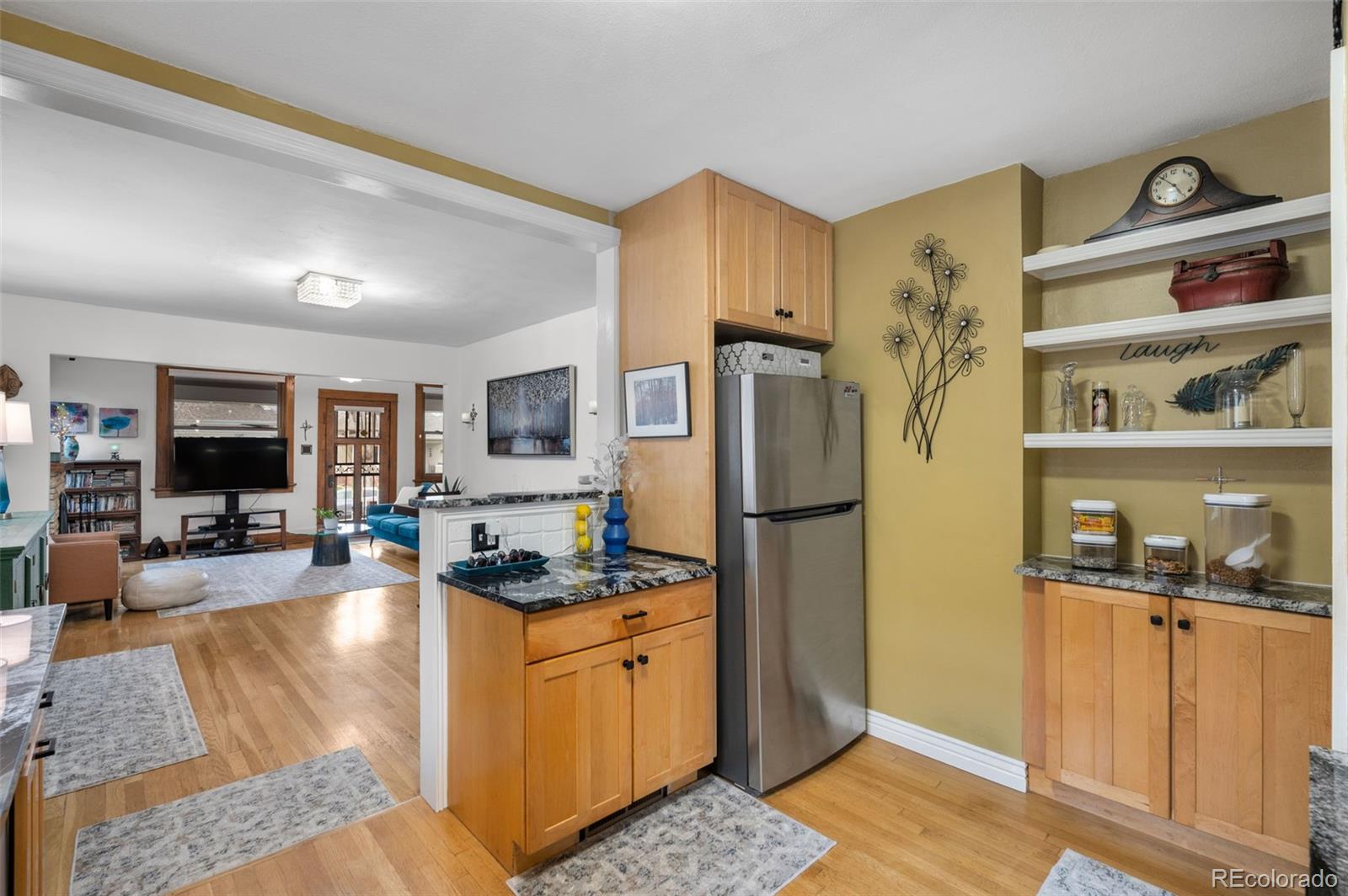 1136 Cook Street Denver, CO 80206 - Photo 15 of 42 a kitchen with stainless steel appliances granite countertop a refrigerator a stove and a sink with wooden floor