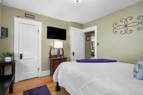 a bedroom with a bed and a flat tv screen on the dresser