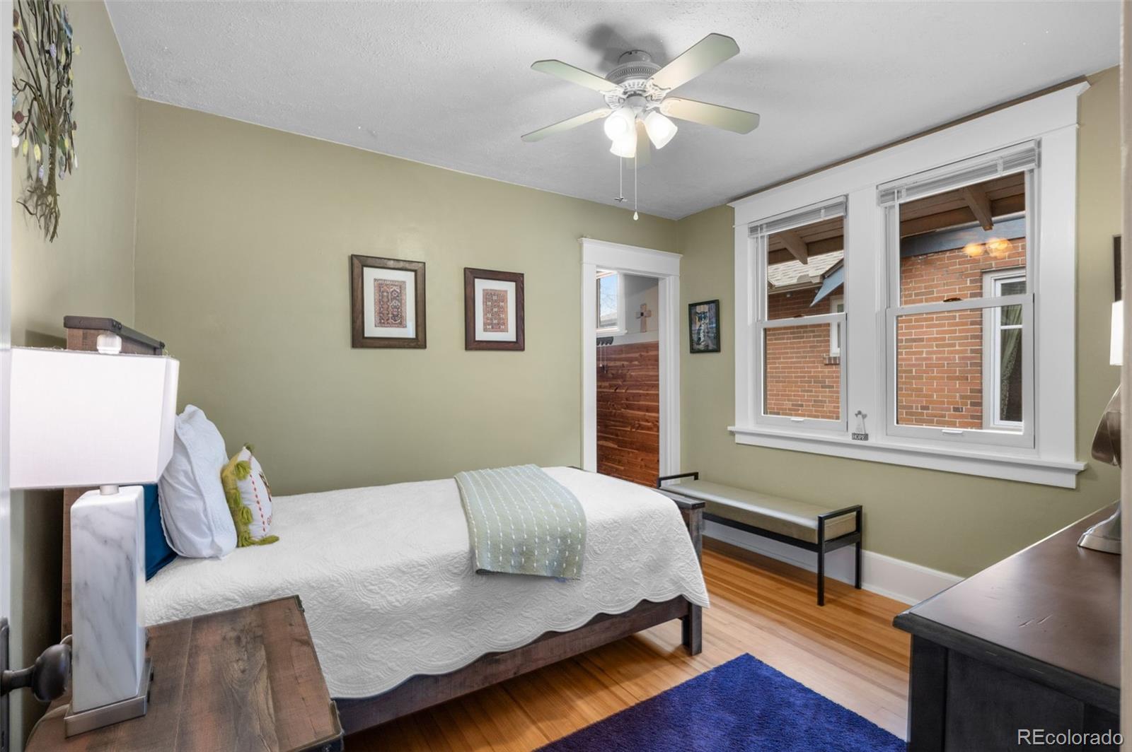 1136 Cook Street Denver, CO 80206 - Photo 19 of 42 a bedroom with a bed wooden floor and a table