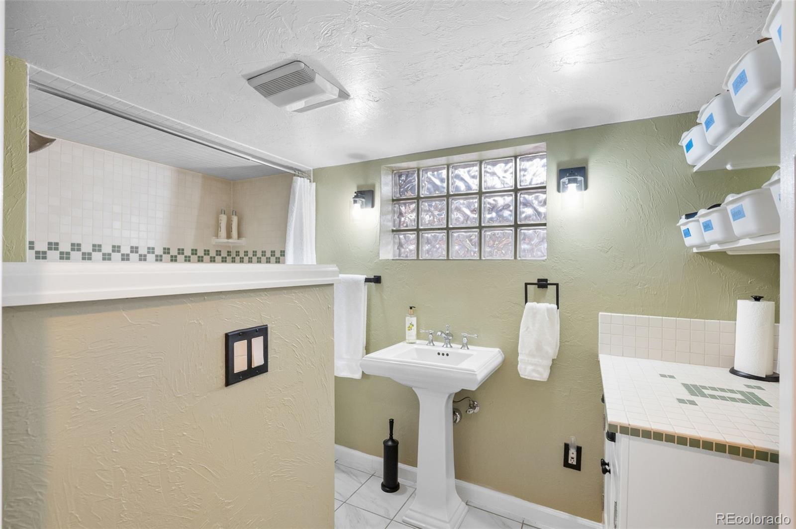 1136 Cook Street Denver, CO 80206 - Photo 25 of 42 a bathroom with a sink a mirror and a shower