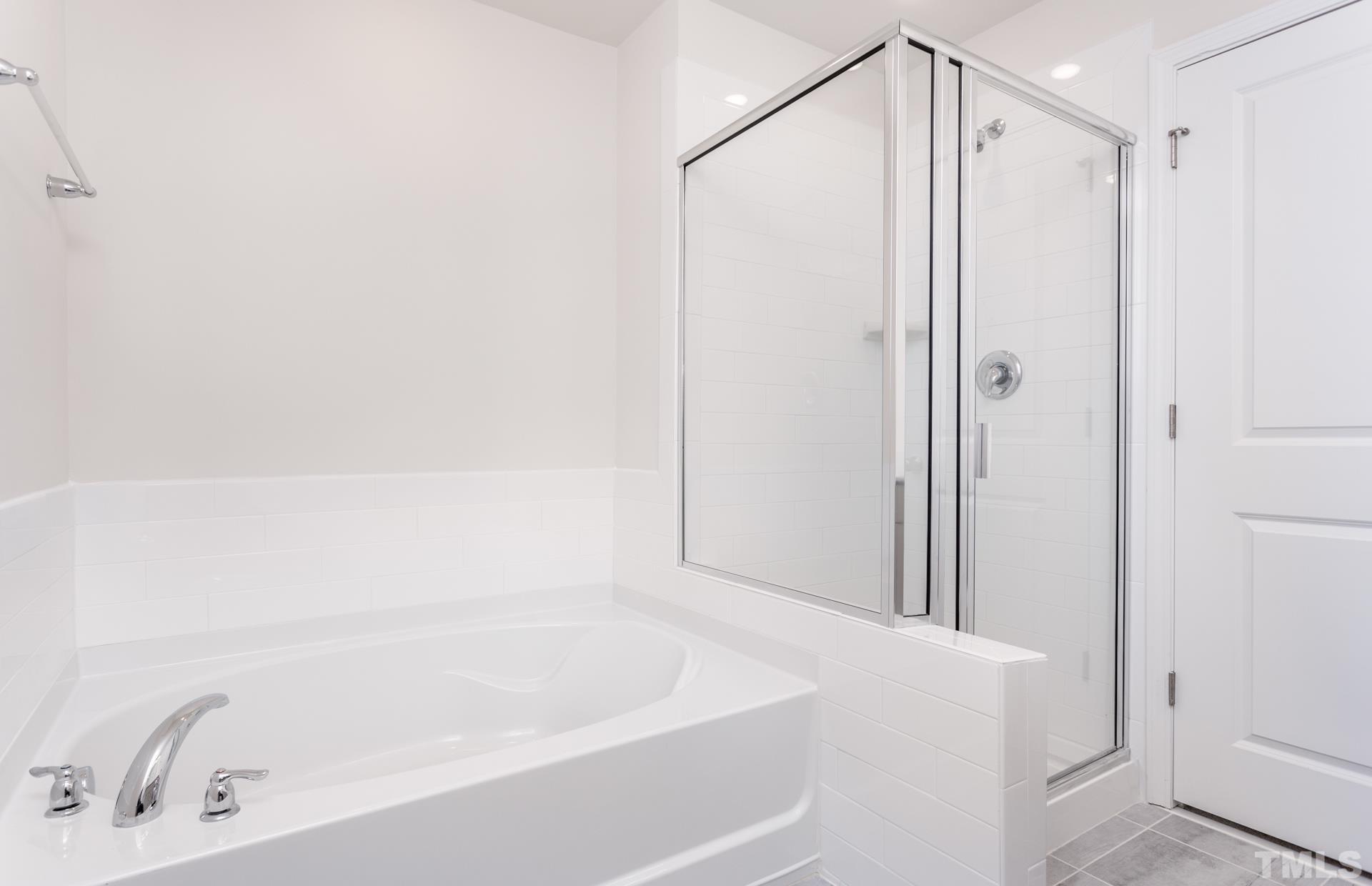 5714 Volos Avenue Raleigh, NC 27603 - Photo 3 of 20 a bathroom with a bathtub and a shower