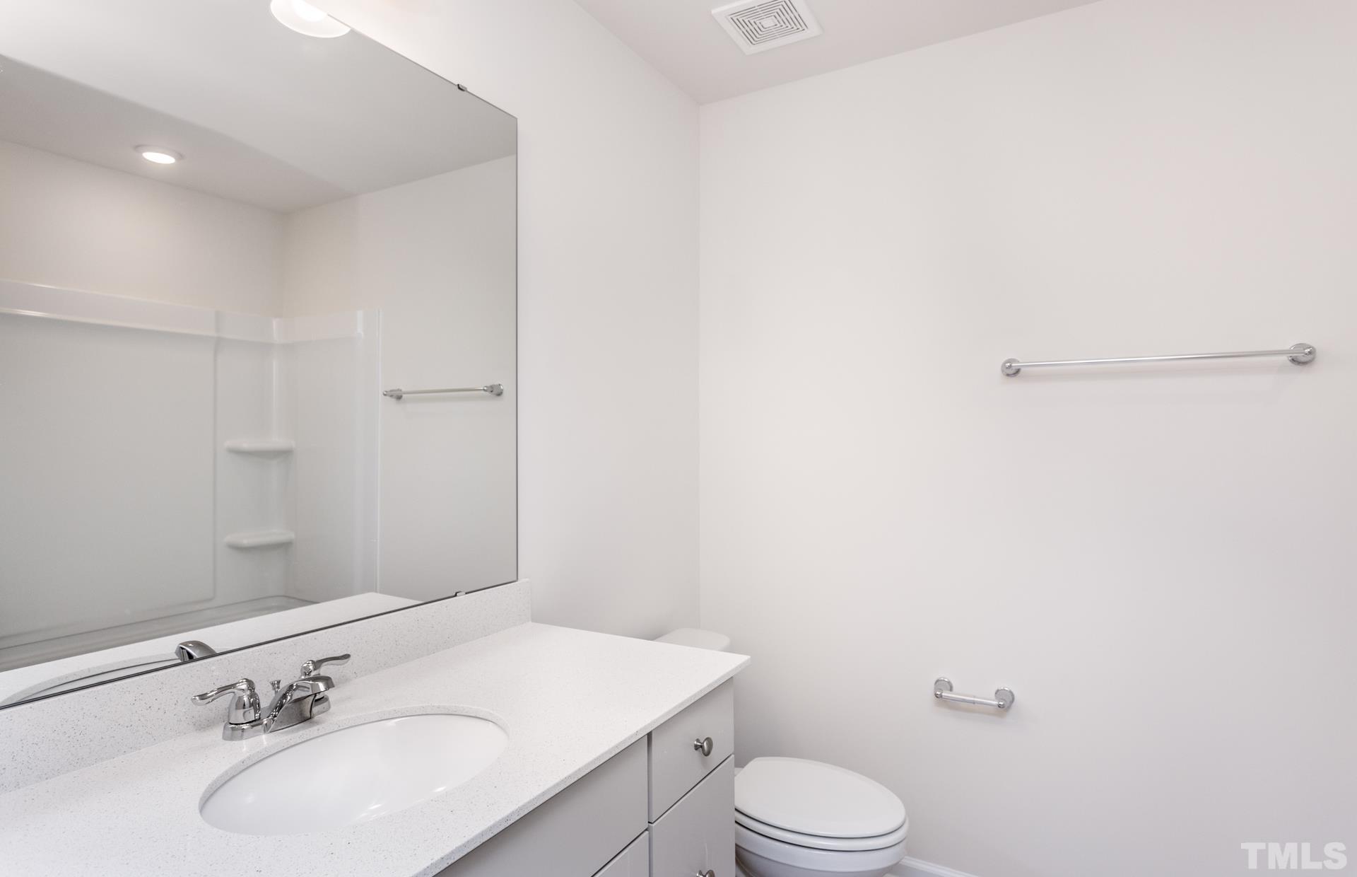 5714 Volos Avenue Raleigh, NC 27603 - Photo 8 of 20 a bathroom with a sink vanity mirror and toilet