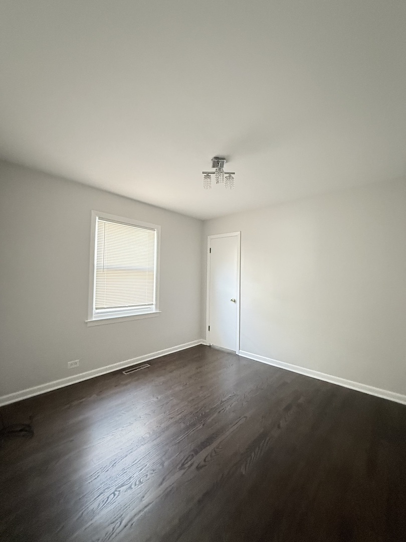 5850 South Neva Avenue Chicago, IL 60638 - Photo 11 of 17 an empty room with wooden floor and windows