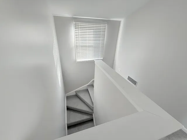 a view of staircase with white walls and a window