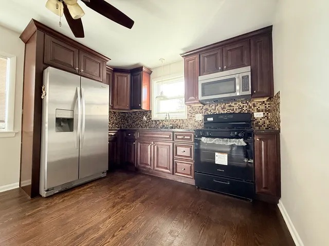 a kitchen with stainless steel appliances granite countertop a refrigerator a stove and a microwave oven