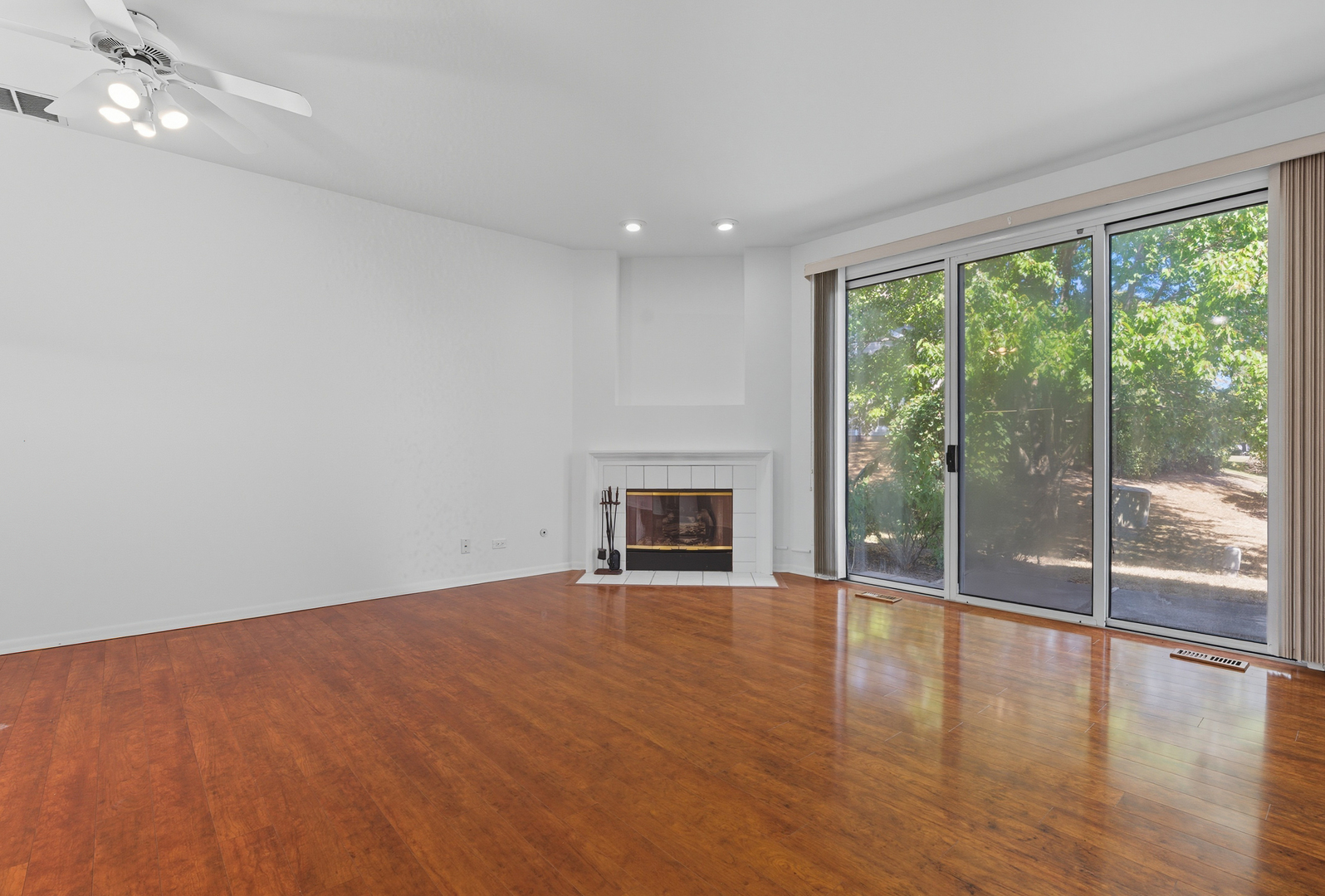 519 Woodcrest Drive, Unit 519 Mundelein, IL 60060 - Photo 8 of 21 a view of empty room with wooden floor and fireplace