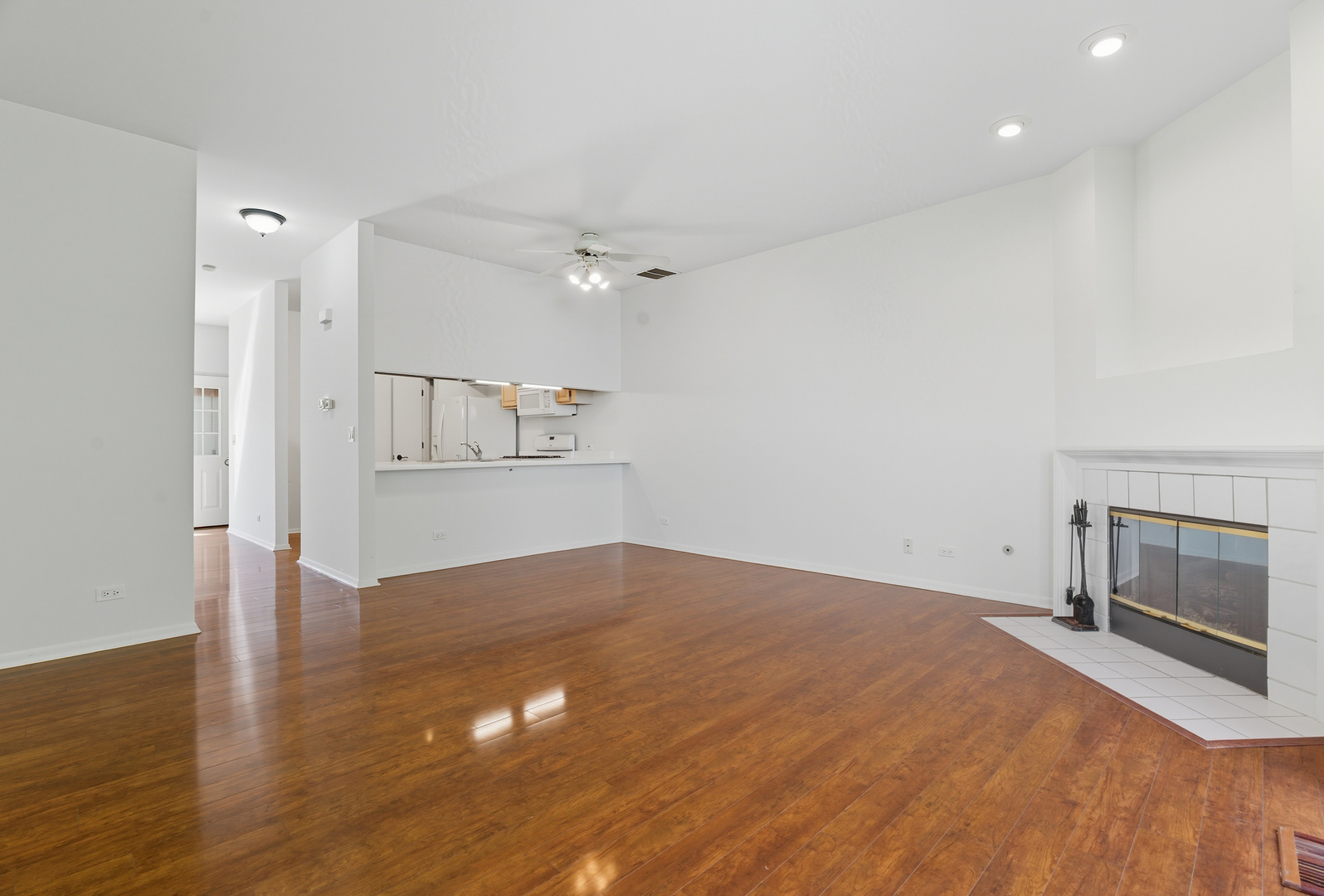 519 Woodcrest Drive, Unit 519 Mundelein, IL 60060 - Photo 9 of 21 an empty room with wooden floor and fireplace