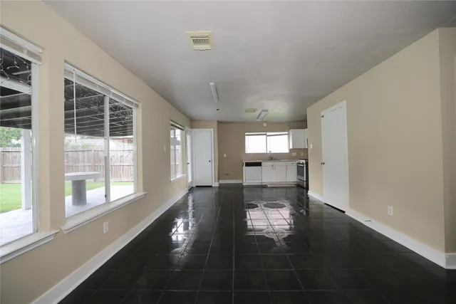 a view of empty room with wooden floor and windows