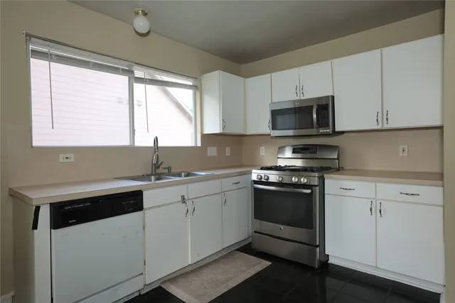 a kitchen with stainless steel appliances granite countertop a sink and a stove