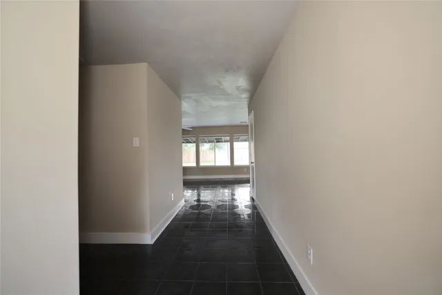 a view of a hallway with wooden floor and a window