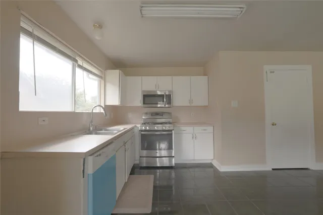 a kitchen with a sink stove and cabinets