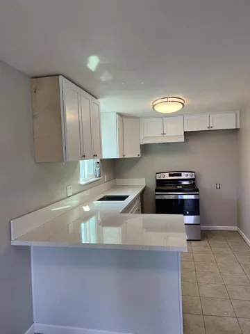 a kitchen with granite countertop a sink and a stove top oven