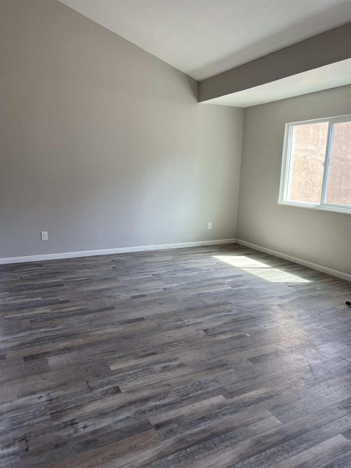 8603 Acapulco Way Stockton, CA 95210 - Photo 10 of 39 a view of an empty room with wooden floor and a window