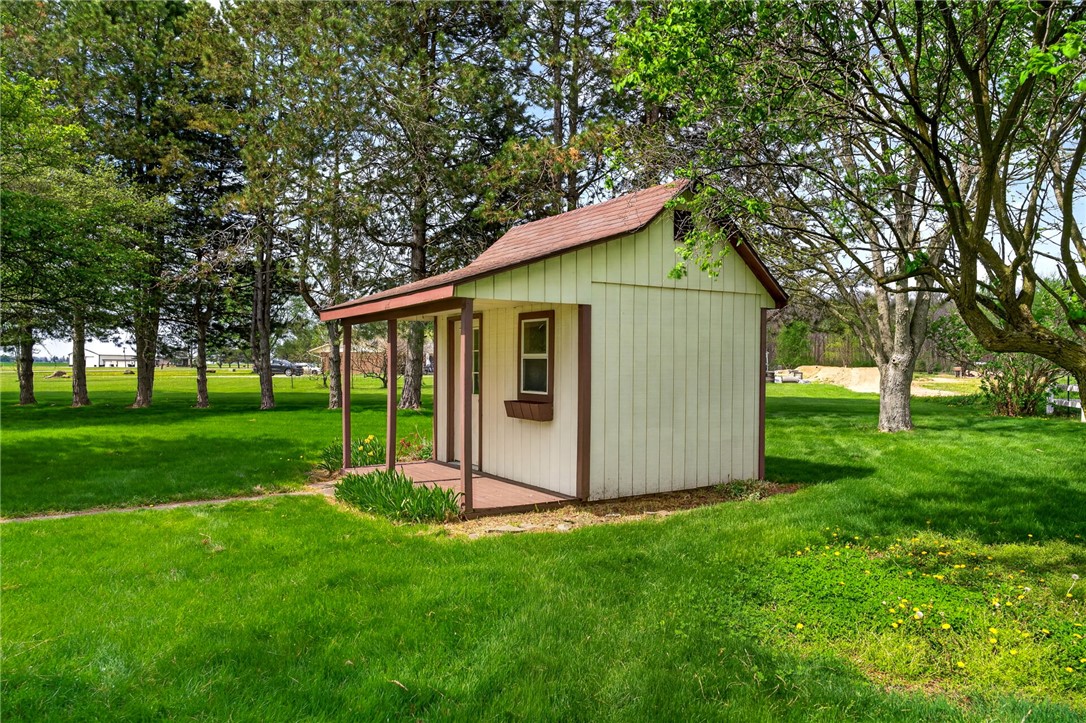 7988 McCool Road Greenville, OH 45331 - Photo 36 of 50 This charming shed with a covered porch offers delightful garden views and lush green surroundings.