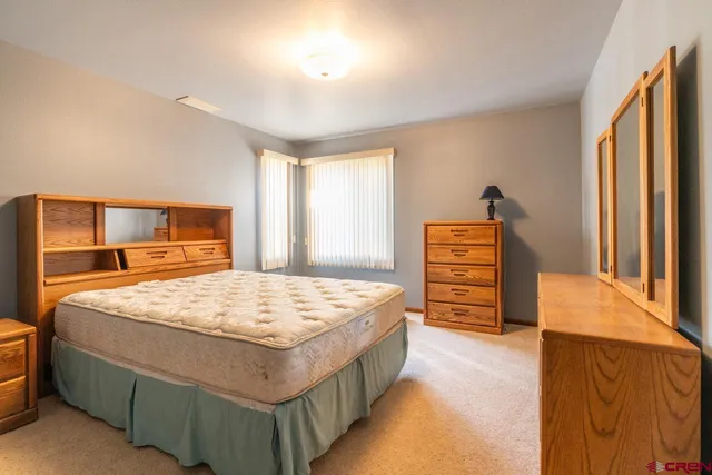 a bedroom with a bed and dresser with mirror