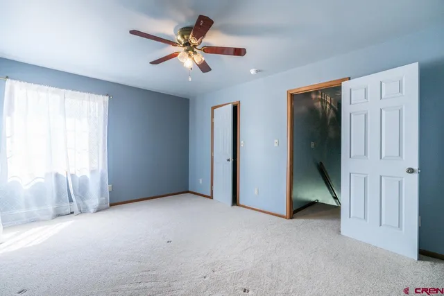 an empty room with closet and windows