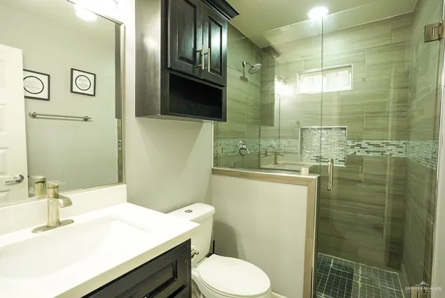 a bathroom with a sink a toilet and shower