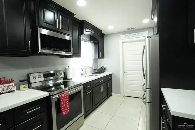 a kitchen with stainless steel appliances a stove microwave and sink