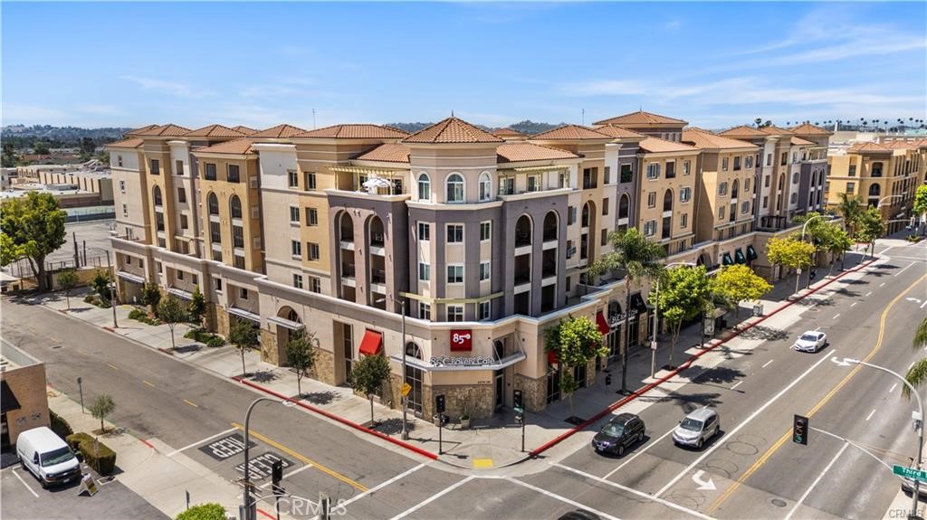 a view of a buildings and cars park side of the road