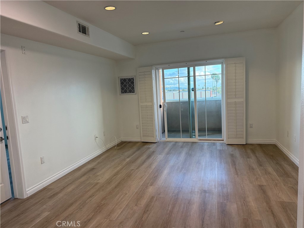 11 South 3rd Street, Unit 218 Alhambra, CA 91801 - Photo 4 of 21 an empty room with wooden floor and mirror