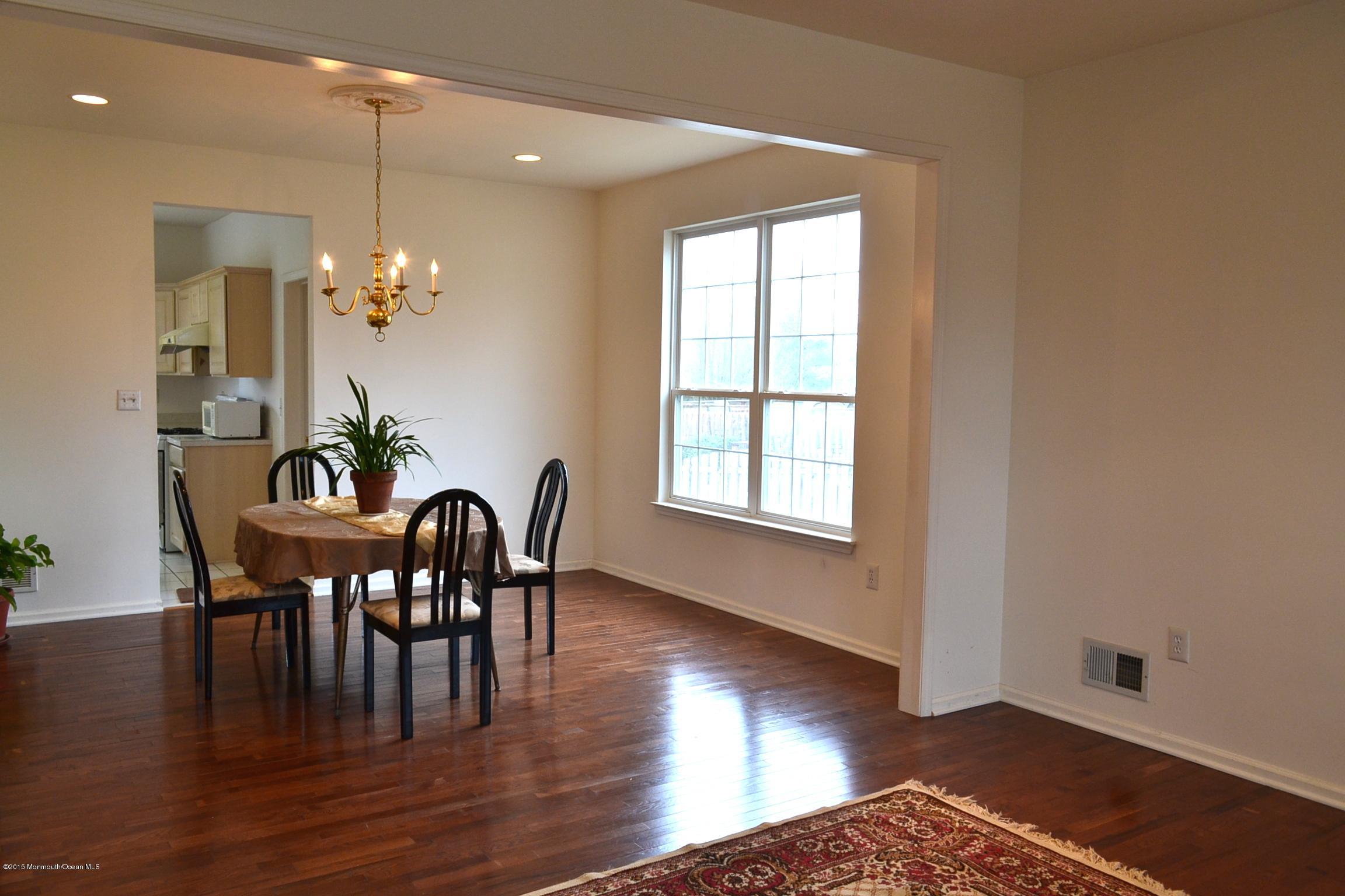 23 Bernadette Road Morganville, NJ 07751 - Photo 3 of 26 a dining room with furniture wooden floor a potted plant and a chandelier