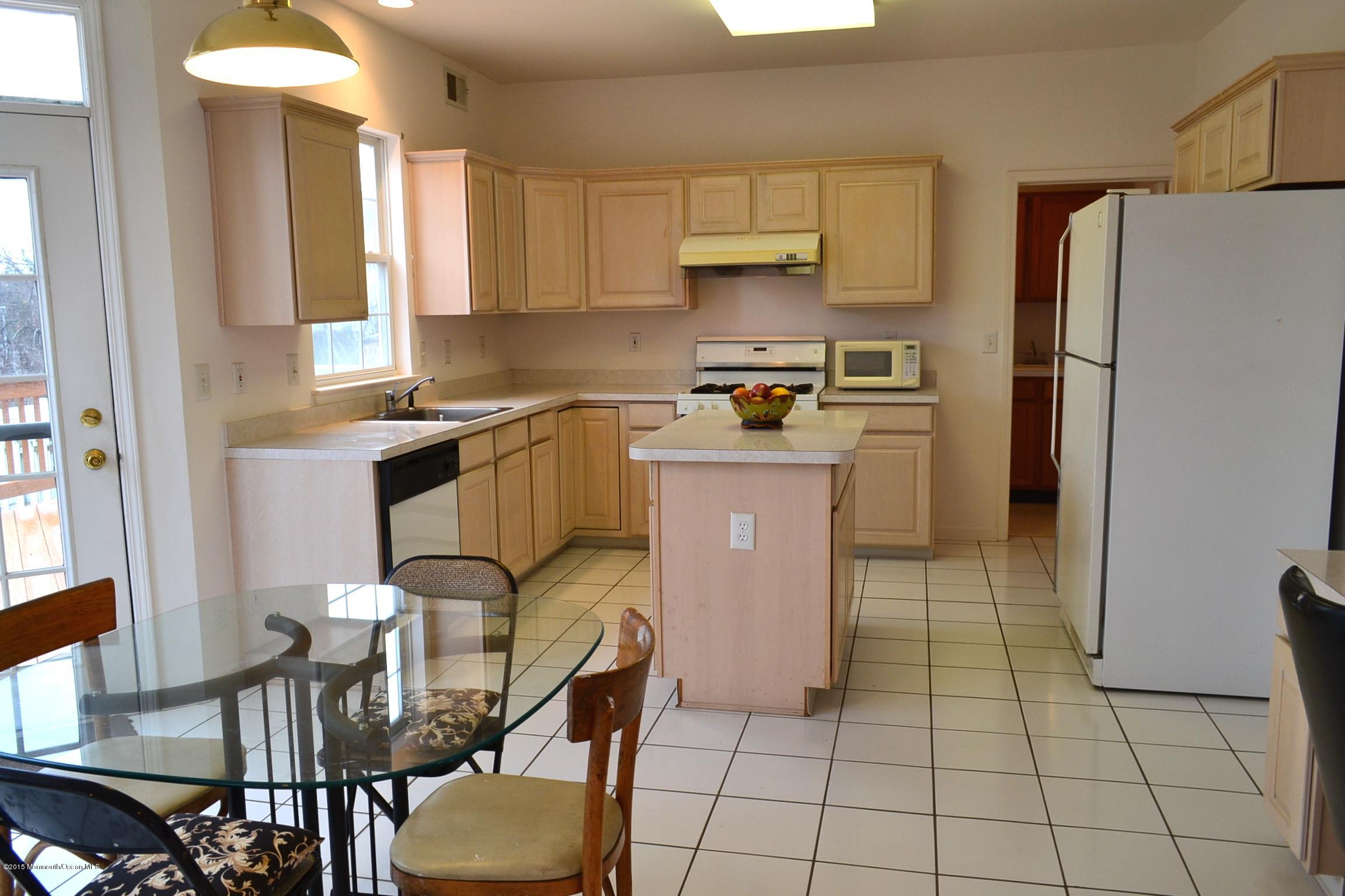 23 Bernadette Road Morganville, NJ 07751 - Photo 6 of 26 a kitchen with stainless steel appliances granite countertop a sink a stove a refrigerator cabinets and dining table