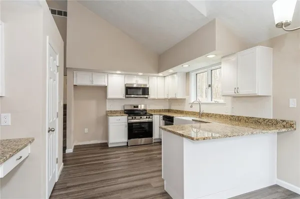 a kitchen with stainless steel appliances granite countertop a stove a sink and a refrigerator