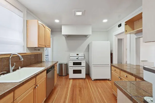 a kitchen with a stove cabinets and wooden floor