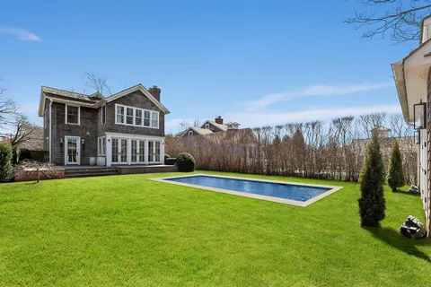 a view of a house with swimming pool and a yard