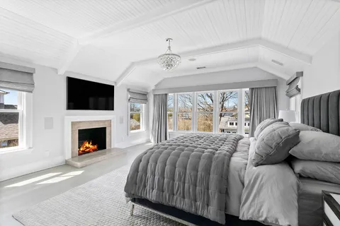 a bedroom with a large bed and a fireplace