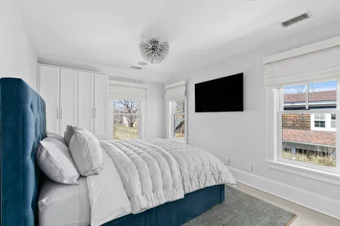 a bedroom with a bed tv and a window