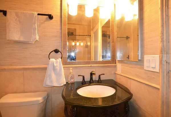 a bathroom with a sink a toilet and a mirror