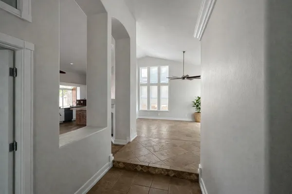 a view of a hallway with bathroom and wooden floor