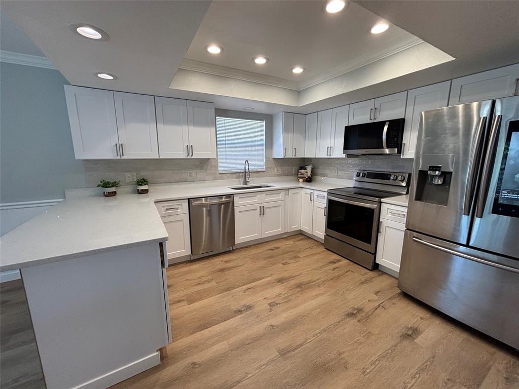 9801 Southeast Sunset Harbor Road Summerfield, FL 34491 - Photo 2 of 37 a kitchen with stainless steel appliances granite countertop a stove top oven a sink and a refrigerator