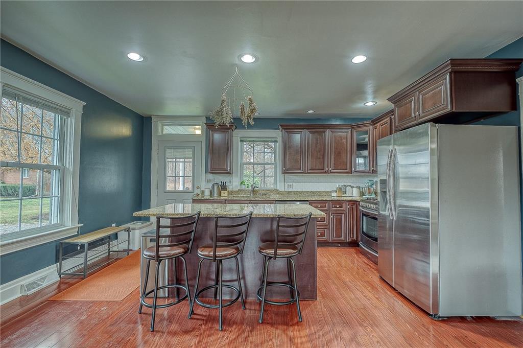 7520 Noblestown Road McDonald, PA 15057 - Photo 4 of 25 a kitchen with stainless steel appliances a dining table chairs and wooden floor
