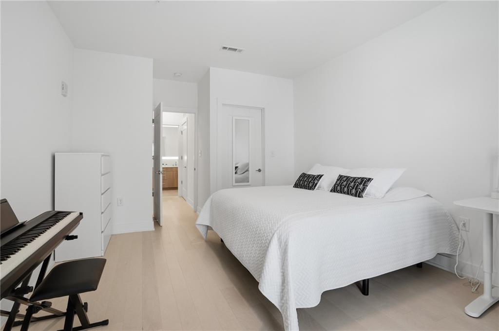 775 Juniper Street Northeast, Unit 322 Atlanta, GA 30308 - Photo 15 of 34 a bedroom with a bed and a chair