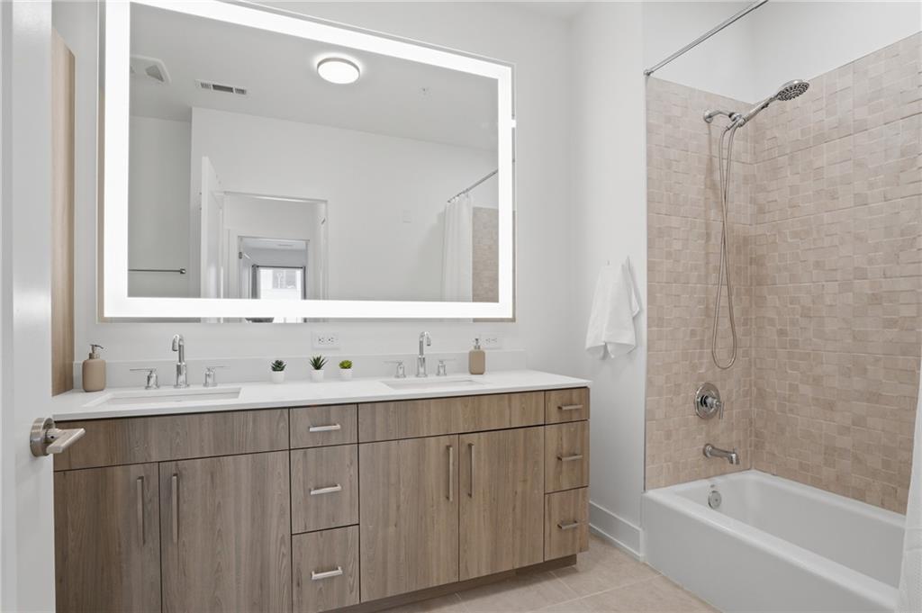 775 Juniper Street Northeast, Unit 322 Atlanta, GA 30308 - Photo 16 of 34 a bathroom with a double vanity sink mirror and bathtub