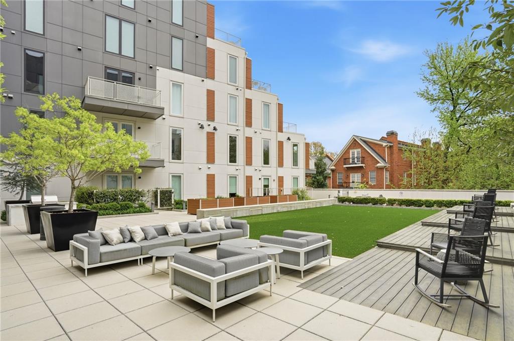 775 Juniper Street Northeast, Unit 322 Atlanta, GA 30308 - Photo 28 of 34 a view of a patio with couches and a table and chairs with plants and trees