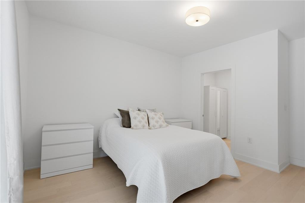 775 Juniper Street Northeast, Unit 322 Atlanta, GA 30308 - Photo 10 of 34 a bedroom with a bed and a night stand