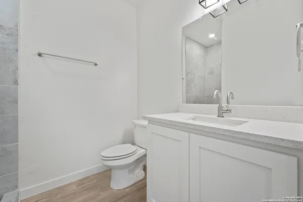 a bathroom with a toilet a sink and mirror
