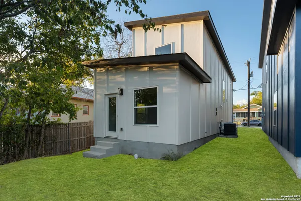 a view of backyard with small cabin and wooden fence