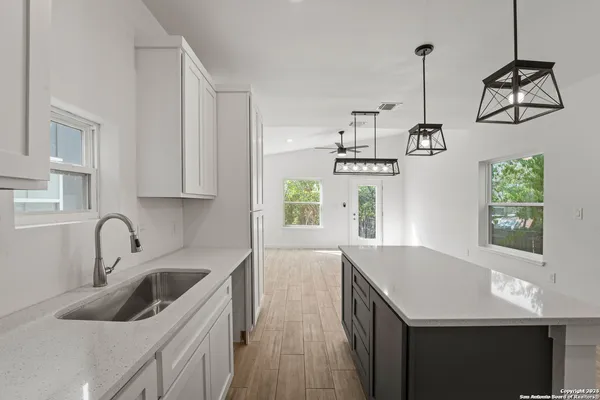 a kitchen with a sink a counter top space stainless steel appliances and cabinets